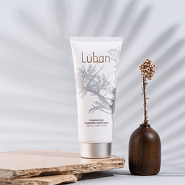 Luban hair conditioner in a tube next to a small pot